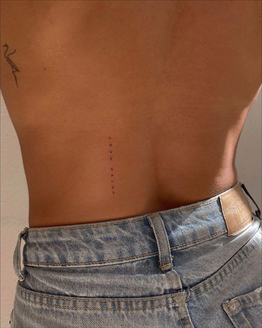 Tatuaje ‘love saves’ en la espalda