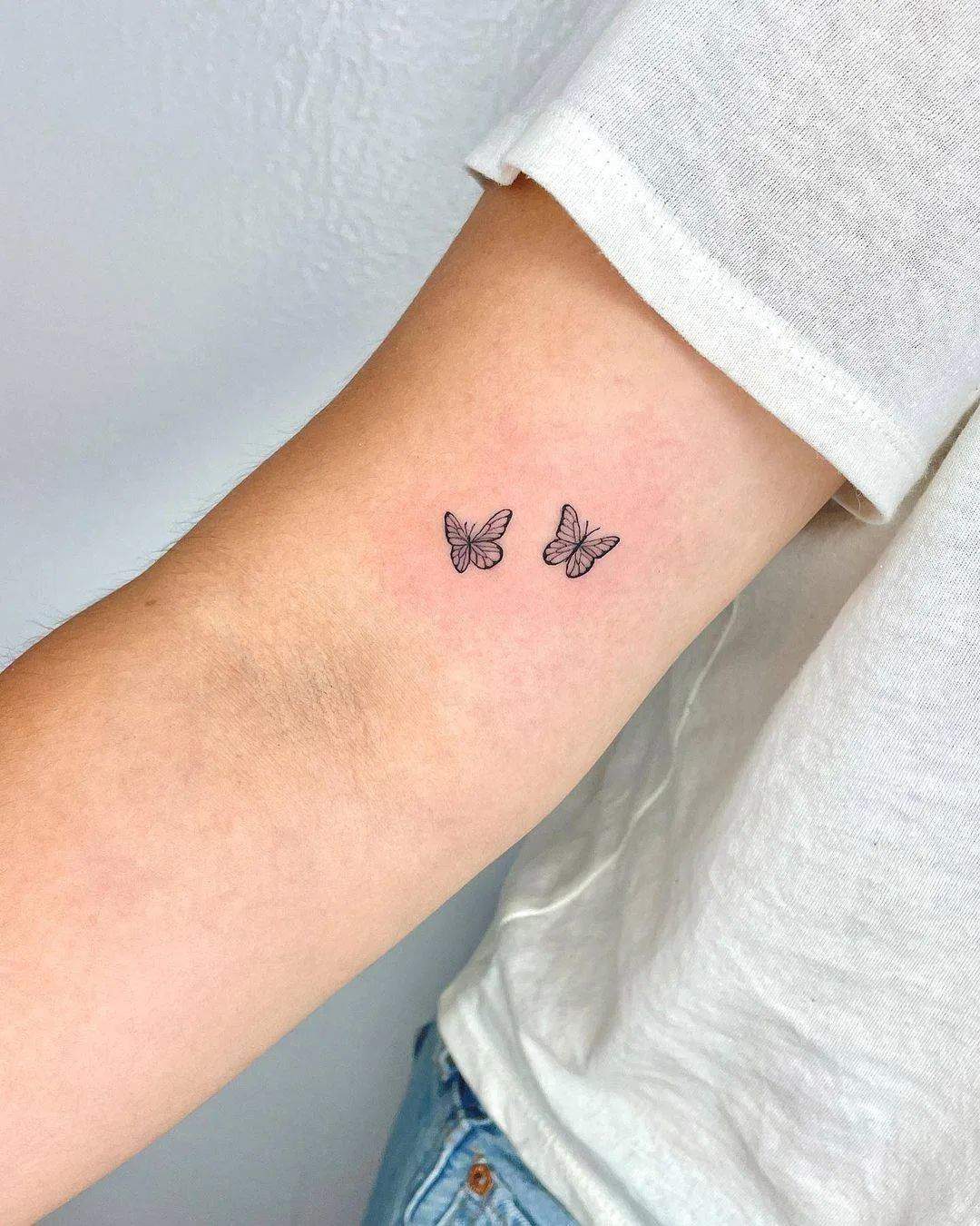 Dos mariposas tatuadas sobre el brazo