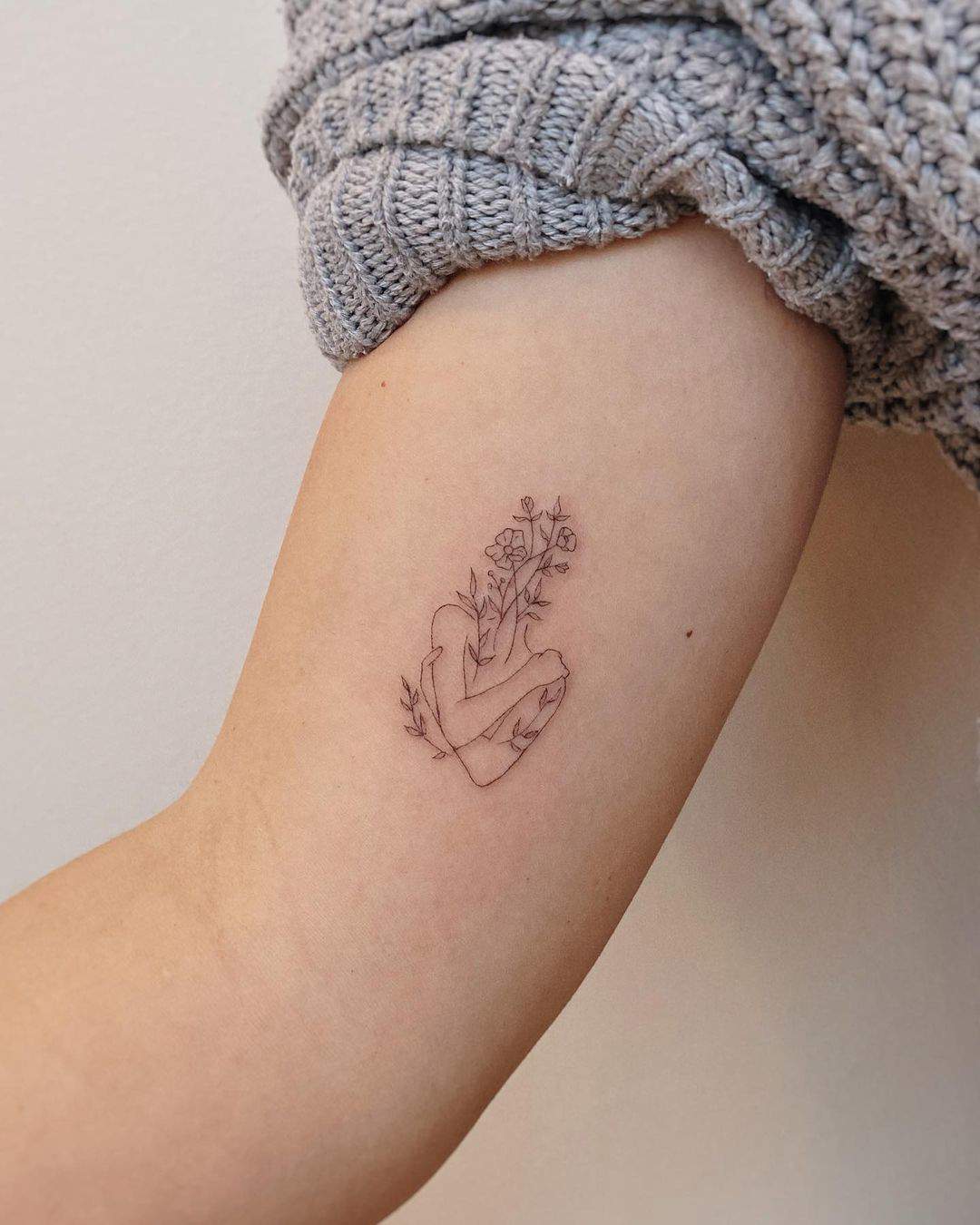 Tatuaje original de abrazo y flores